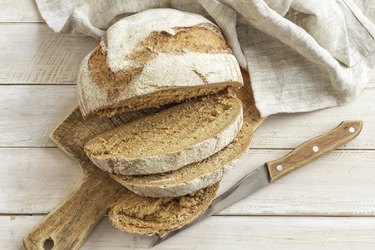 Bread on wooden cutting board with knife