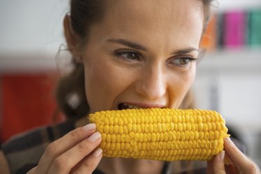 young woman eating boiled corn