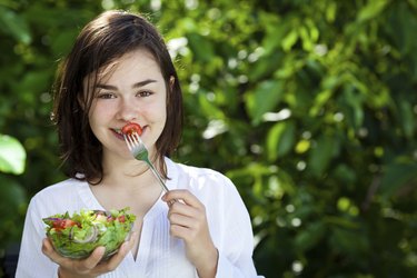 Girl eating vegetable salad