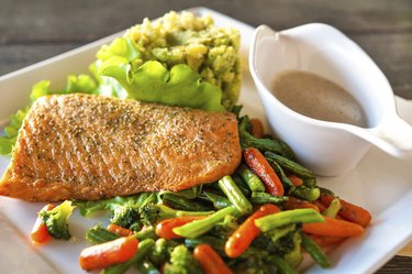 Grilled salmon fillet with potato-spinach mash and vegetables.