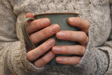 Two hands holding a mug of drink