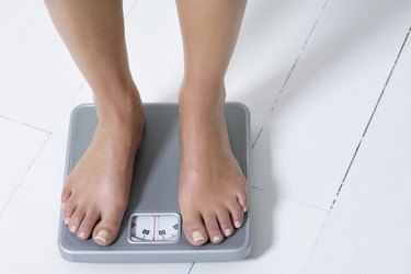 Young woman weighing herself