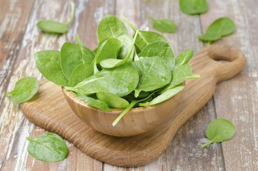 Fresh spinach in a wooden bowl, horizontal