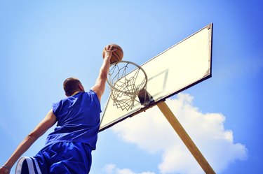 Basketball player in action flying high and scoring