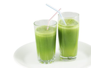 Green vegetable juice in the glasses with straws