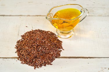 brown flax seed and linseed oil, on wooden table