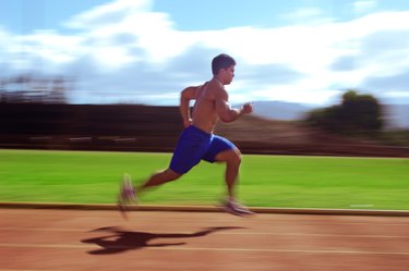 Man Running on Track With Shirt Off