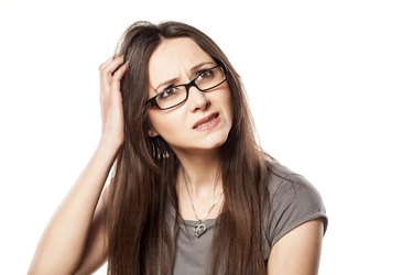 Young woman with questionable gesture scraping her hair