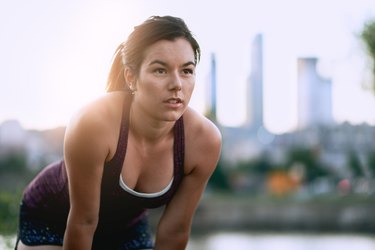 Portrait of active millenial woman jogging at dusk with an