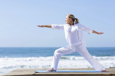 mature woman yoga exercise on beach