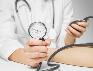 Doctor measures blood pressure by sphygmomanometer