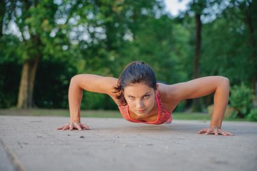 fitness girl doing pushups in park