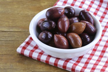 ripe black kalamata olives in a white bowl