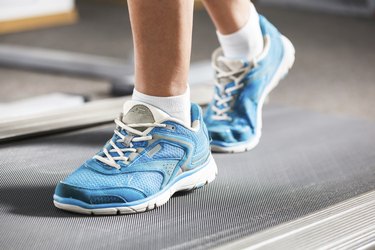 Woman running on treadmill in gym.