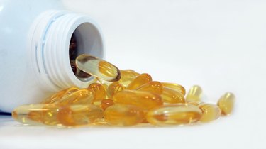 fish oil tablets spilling from prescription bottle