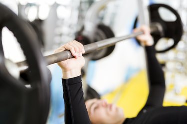 Young handsome man doing exercises on a bench press