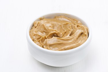 bowl of peanut butter on white wooden table