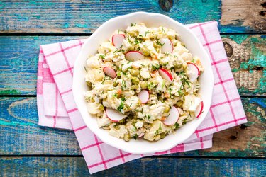 potato salad with fresh radishes in a bowl top view