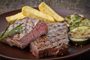 grilled beef steak on wooden cutting board