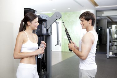 A man working out on his arms while woman is looking