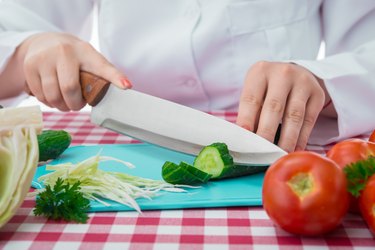 female cook slicing vegetables