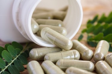 Herb capsules spilling out of bottle