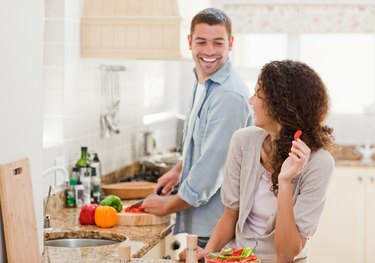 Beautiful woman looking at her husband who is cooking