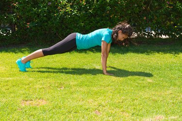 Young athletic woman does push-ups training outdoor