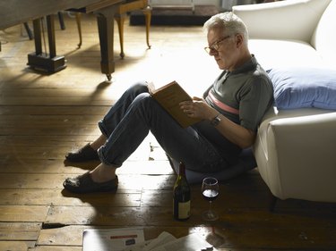 Mature man sitting on floor, reading