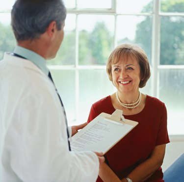 portrait of an elderly woman talking to a male doctor