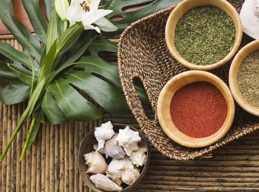 Spices and conch shells on wicker table, overhead view