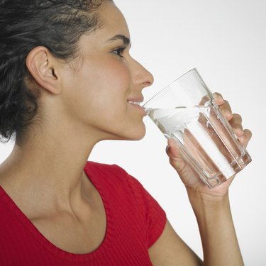 Hispanic woman drinking glass of water