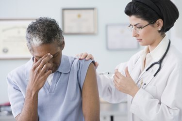 Middle Eastern female doctor giving shot to patient