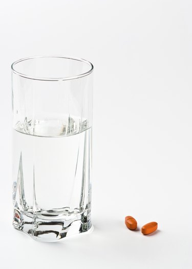two pills and glass of water