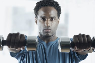 Close-up of a mid adult man holding dumbbells