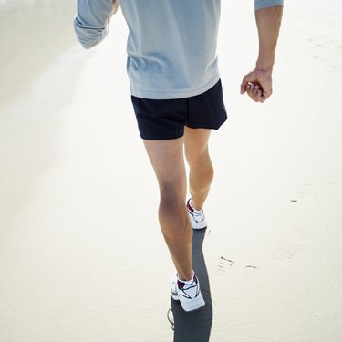 Close-up of the legs of a man walking on the beach