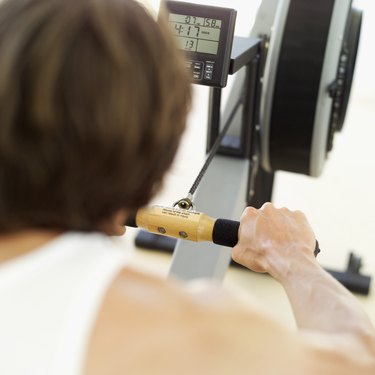 Rear view of a young man exercising on a rowing machine