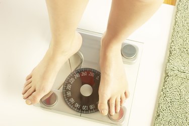 close up of feet standing on a bathroom scale