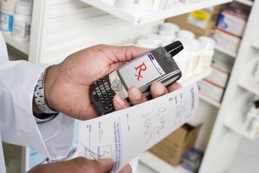 Man holding prescription and portable communication device