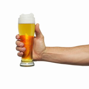 Close-up of man's hand holding glass of beer