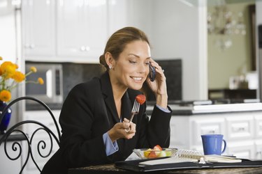 Hispanic businesswoman eating breakfast