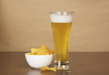 Glass of cold beer and chips on the plate
