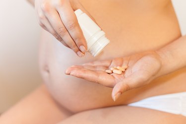 Pregnant woman uses vitamin tablets