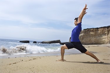 Man doing yoga on beach