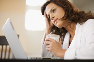 Distraught woman working at home with laptop computer