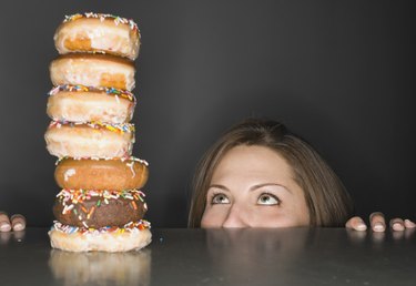 Woman looking at stack of donuts in awe