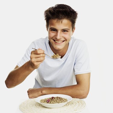 portrait of a teenage boy eating cereal from a bowl