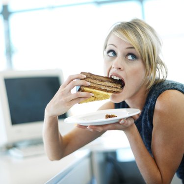 close-up of a woman eating a large piece of cake