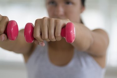 Portrait of a young woman exercising with weights