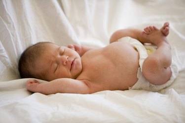 Newborn baby lying on bed